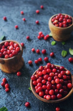 Ham organik taze böğürtlen veya lingonberry ahşap kaseler koyu taş masada, sağlıklı yaşam tarzı kavramı