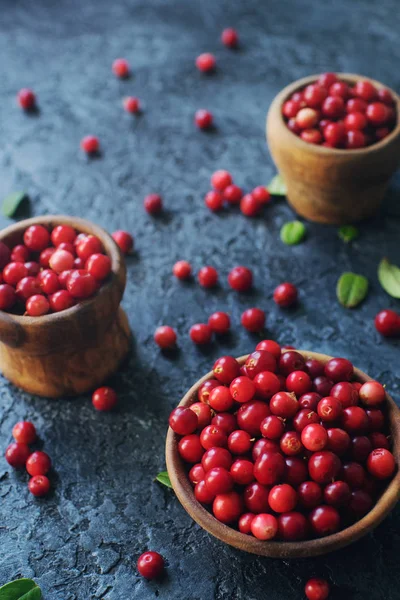 Ham organik taze böğürtlen veya lingonberry ahşap kaseler koyu taş masada, sağlıklı yaşam tarzı kavramı