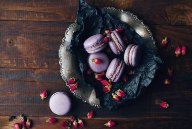 Mor lavanta ya da böğürtlenli badem kurabiyesi ve koyu ahşap masada kuru lavanta.