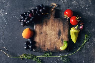 Köy ahşap kesim tahtasının etrafında çiğ taze meyve ve sebzeler. 