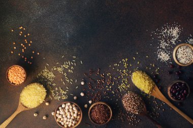 Tahta kaşık ve kaselerde çeşitli organik tahıl ve tahıllar var.