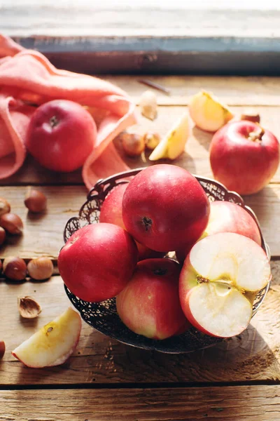 Cozy morning autumn composition fresh organic apples and nuts on rustic wooden table, selective focus