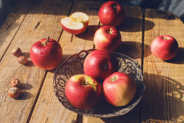 Cozy morning autumn composition fresh organic apples and nuts on rustic wooden table, selective focus