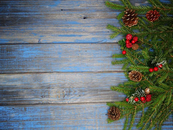 木の板にモミの枝でクリスマス背景および円錐形装飾 — ストック写真