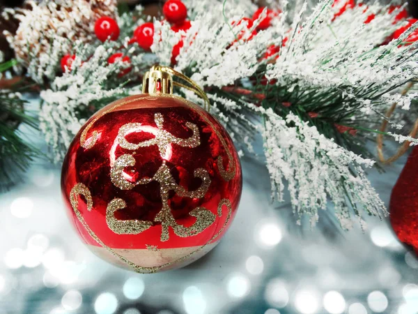 Christmas ball on fir tree branch with cones and snow on backgro Stock Image