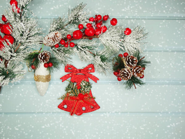 christmas bell on fir tree branch with cones and snow on backgro