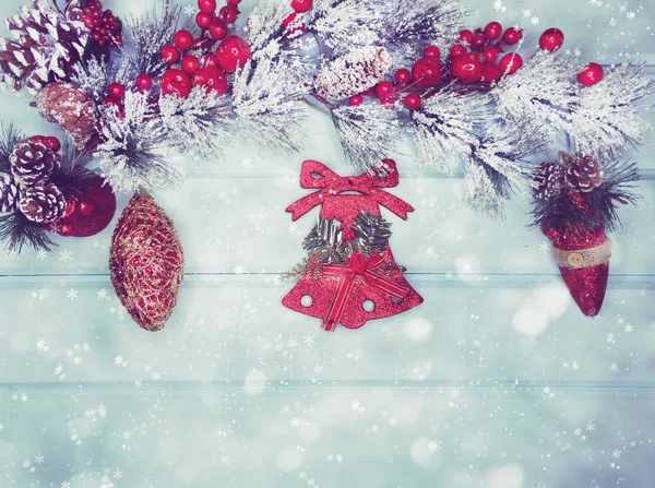 पृष्ठभूमि पर शंकु और बर्फ के साथ खजूर के पेड़ की शाखा पर क्रिसमस बेल — स्टॉक फ़ोटो, इमेज