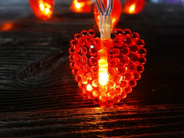 Ghirlanda cuori luce San Valentino su scuro vecchio backgrou di legno — Foto Stock