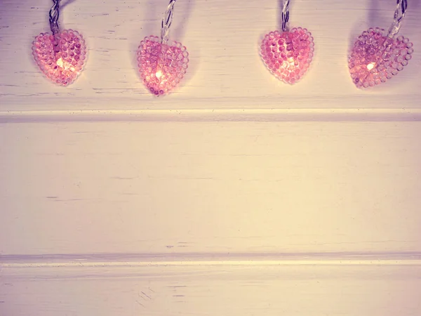 Garland harten licht valentine's dag op witte houten achtergrond — Stockfoto