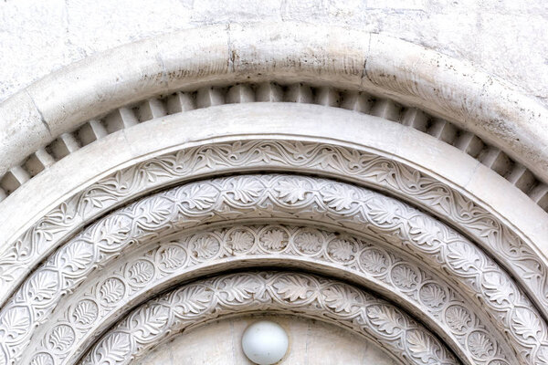 Vladimir, Russia - September 28, 2018: Exterior architectural elements. Carving on white stone. CathedralAssumption of the Blessed Virgin (Uspenskiy). Archival, framing arched doorway