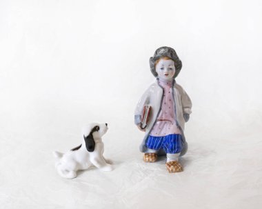 Fayans minyatür. Eski Rus Ulusal giysiler ve bir köpeğin beyaz bir arka plan üzerine bir kitap ile bir çocuk giyinmiş.