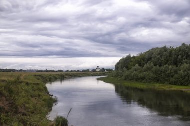 Bulutlu yaz Rus manzara: nehir, alan, kilise - Rusya'nın tüm sembolleri - soğuk bulutlu bir günde