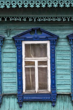 Zencefilli kekin ahşap kesimi. Eski ahşap bir evin mavi pencere süslemesi. 