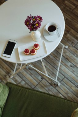 kafede masada kek, kahve ve smartphone üstten görünüm 
