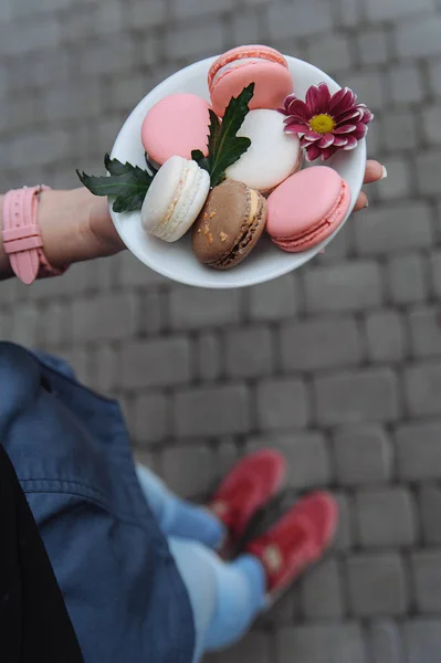 Mujer Sosteniendo Coloridos Macarrones Plato Blanco —  Fotos de Stock