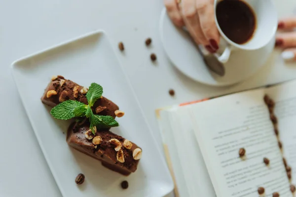 Çikolatalı Kek Kitap Kahve Fincanı Tutan Eller Yakın — Stok fotoğraf