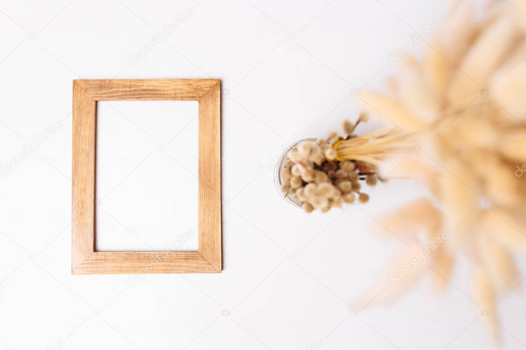 Wooden photo frame and flowers on the white background.