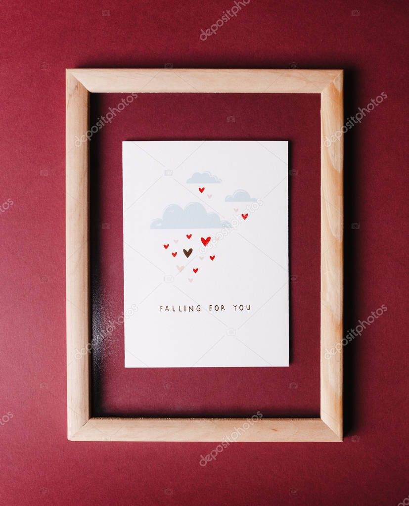 Valentines day card in the wooden frame on the red background