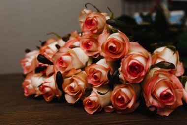 Ahşap masa üzerinde pembe gül buketi