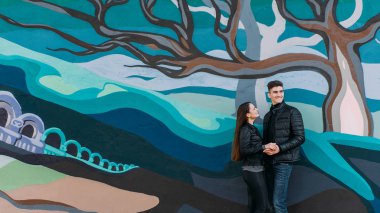 Kız grafiti önünde duran erkek arkadaşı izliyor