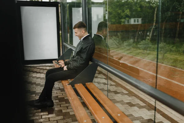 Hombre Sentado Parada Del Autobús Escribiendo Mensajes Teléfono —  Fotos de Stock