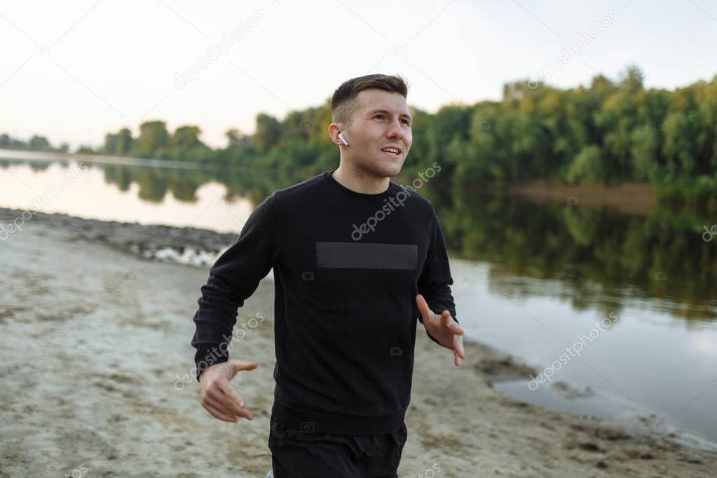 Portrait of the young man running in the morning with the earphones
