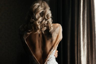 Düğmeleri iliklenmemiş gelinlikli sarışın gelin.