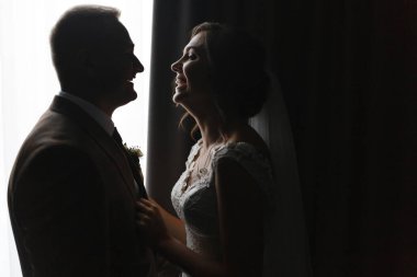 Gülümseyen gelin ve damadın silueti birbirine bakıyor. Gelin ve damat portresi. Düğün fotoğrafçılığı