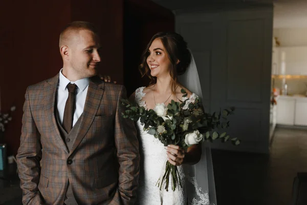 チェッカージャケットと花嫁の新郎新婦がお互いを見て結婚式の花束で 花嫁と新郎の肖像画 ウェディング写真 — ストック写真
