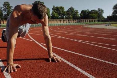 Gömleksiz, kaslı bir adam stadyumda şınav çekiyor. Sporcu. Güçlü adam.