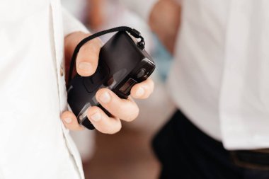 Küçük siyah kamera insan ellerinde. Kamerayı tutan adam