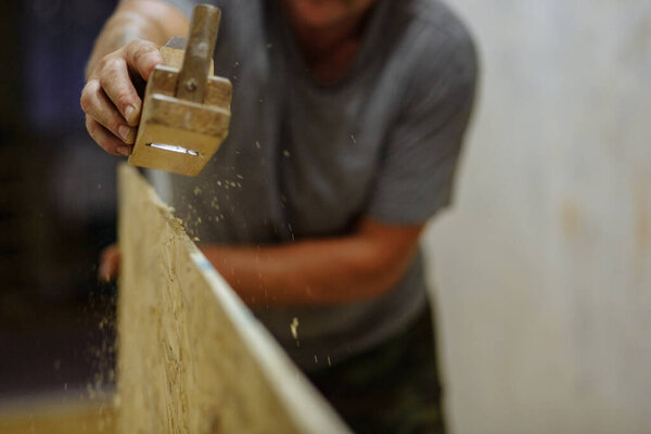 Man grinding the wood. Man working with wood. Home repair. Texture