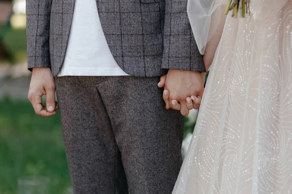 Novia y novio sin rostro tomándose de las manos. Manos de la feliz pareja —  Fotos de Stock