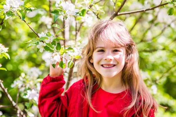 Portrét usmívající se 7 let staré dívky s větví kvetoucího — Stock fotografie
