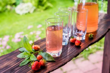 Bir tam ve üç boş bardak ve meyve suyu sürahi. Strawbe