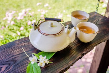 Çaydanlık ve tahta masada iki fincan çay. Yaz