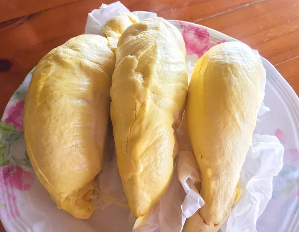 Durian is on the white plate at wooden table, this is the king of fruit in Thailand which is yellow and gold color. It is sweet and delicious, it is call Mon Thong that is one kind of Durian