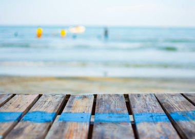 Eski ahşap masa plaj yerleştirilir. Mavi bir çizgi tablodur. Arka plan bulanık olan mavi deniz tablodur. Duvar kağıdı veya zemin veya ekran için