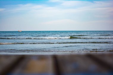 Plajın yer eski ahşap masa bulanık görüntü. Masa mavi deniz ve gökyüzü temizleyin. Arka plan veya duvar kağıdı veya zemin veya ekran için