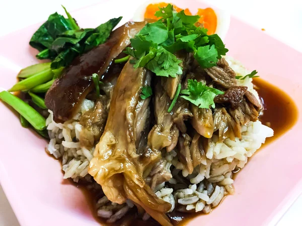 Stewed pork leg on rice. This is Thai food, eaten with rice, boiled kale, fresh garlic, fresh chilli, boiled egg and spicy sauce — Stock Photo, Image