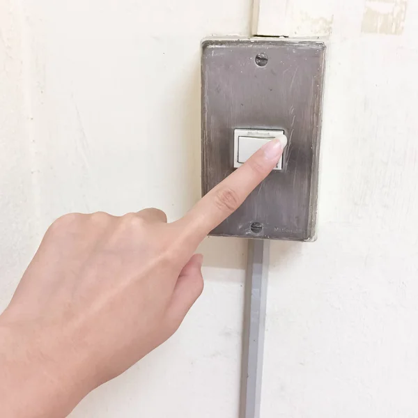 Do not forget to turn off the lights. The women are using her hand to turn off the lights, the  switch are on the white wall. It is energy saving