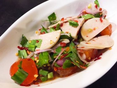 Baharatlı ve ekşi Tay salata tuzlu yumurta sarısı, beyaz domuz sosis ve bahar soğan, maydanoz, kurutulmuş biber ve soğan gibi sebzeler ile giyinmiş