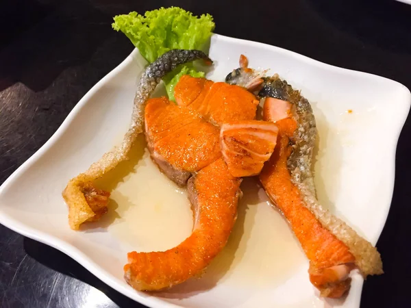 Ce menu est Saumon frit avec sauce au poisson. C'est saumon orange, décoré avec un petit légume sur le plat pour paraître attrayant — Photo