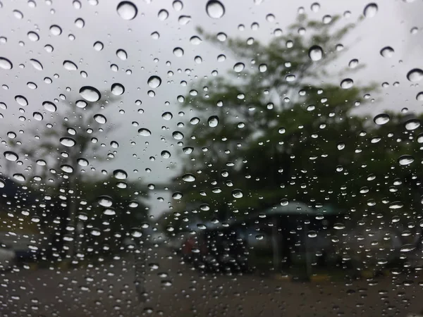 Капли дождя на лобовое стекло, лобовое стекло или стекло автомобиля. Вид изнутри автомобиля на сером фоне неба — стоковое фото