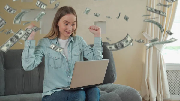 Sikeres fiatal nő, aki laptopot használ az online üzletben, hogy pénzt csináljon a bankjegyekből. A dollár csökken.. — Stock Fotó