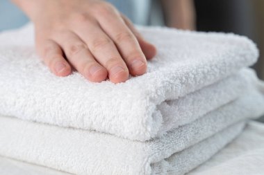 Bir kadın beyaz bir havluya dokunuyor.