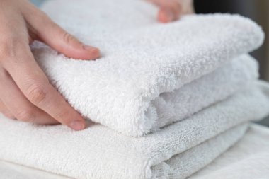 Bir kadın beyaz bir havluya dokunuyor.