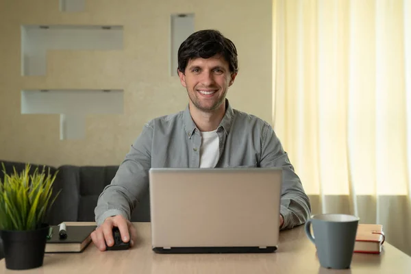 Hombre sonriente usando el ordenador portátil estudiando trabajando en línea en casa — Foto de Stock