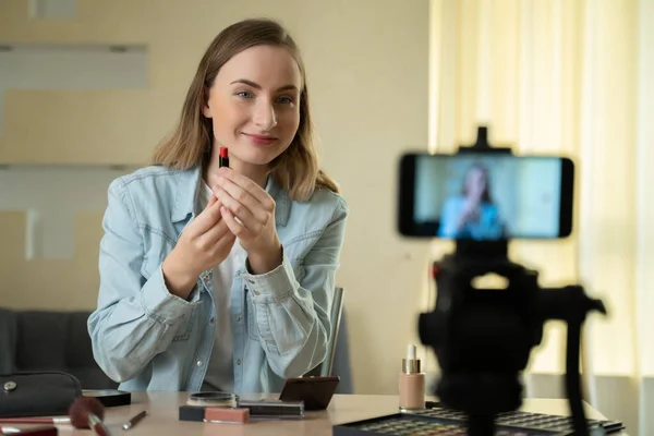 Блогер красоты снимает учебник макияжа на камеру. Влиятельная женщина в прямом эфире обзор косметики продукт в домашней студии — стоковое фото