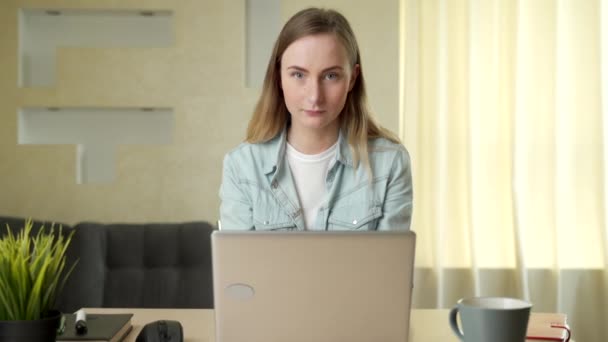 Mooie jonge vrouw werken op laptop computer terwijl zitten in de woonkamer — Stockvideo